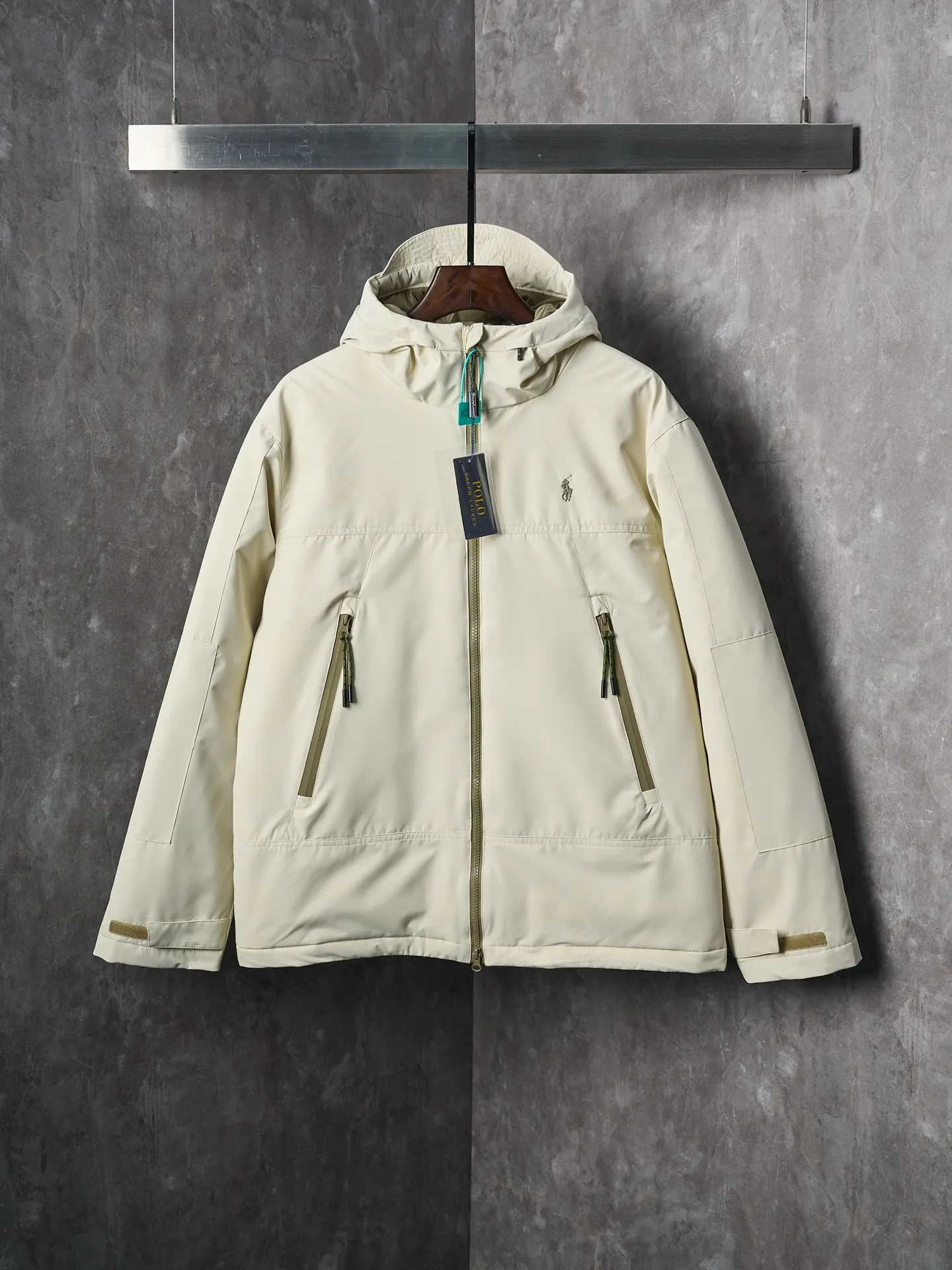 P980 Actual auction】Ralph Lauren/Ralph Lauren pony embroidered zipper hooded down jacket [Ready stock] S M L XL high-quality filling: 90 white duck down is selected, weighing 220g, ensuring excellent thermal insulation performance. After strict screening and processing, the velvet is not easy to be drilled, ensuring durability. The density of high-density nylon taffeta is about 210T-300T, with a smooth and slightly matte surface, excellent windproof and waterproof properties (with DWR water-repellent treatment), strong wrinkle resistance and easy care, in line with the positioning of American casual "durable and practical".  The inner lining is made of 100% polyamide. The high-density and tight weaving process prevents fine lint from getting out of the gaps in the fabric. The smooth surface improves the putting on and taking off experience, and the excellent wear and tear resistance ensures damage caused by frequent use, while the light and soft texture does not affect the overall weight.  The classic jacket has a slightly loose fit, slightly dropped shoulder line (shoulder width is 1-2cm wider than the standard fit), is hip-length, and has slightly tapered straight sleeves, taking into account both freedom of movement and casual style.  The adjustable Velcro on the cuffs allows you to freely adjust the tightness according to the thickness of your wrist and personal preferences, effectively preventing cold wind from intruding, and improving the warmth performance.  In terms of storage, the two front zipper pockets are convenient for you to place frequently used items, and the zipper design ensures that items are not easily lost. A built-in pocket on the left side of the chest provides a safe storage space for some small private items.  The drawstring design at the hem allows you to adjust the shape of the jacket according to your body shape and dressing needs. Whether it is loose and casual or slim and neat, you can easily control it.  Embroidery technology: Polo horse logo on the left chest: flat satin stitch embroidery (satin embroidery), embroidery thread: 100% polyester high color fastness embroidery thread (the color number is consistent with the brand’s standard red color card), stitch density 12-15 stitches/cm, the outline of the horse logo is clear, and the details of the rider and horse are burr-free.  Embroidery positioning: precise positioning through the template (12cm from the neckline and 8cm from the placket) to ensure left and right symmetry and centering.